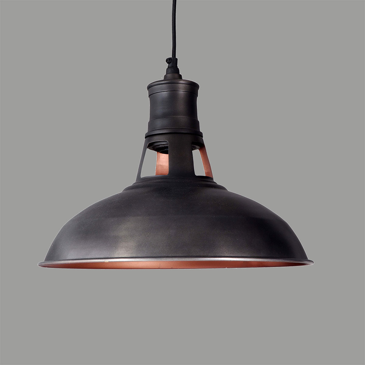 Dark bronze metal pendant lamp with copper lining on a plain grey ground