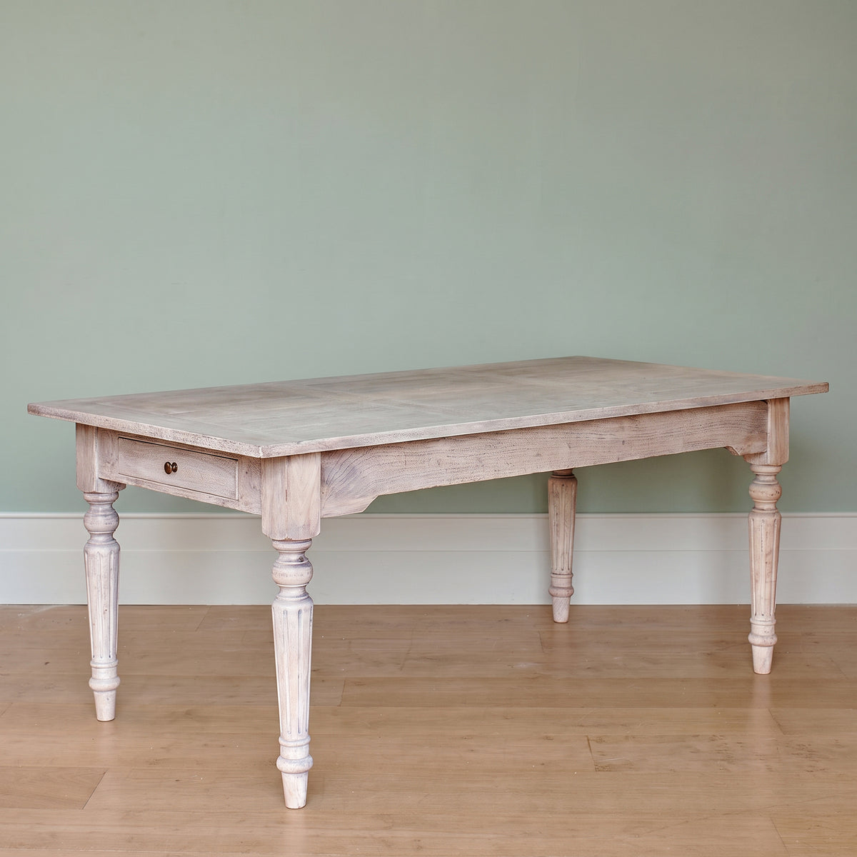 Gustavian dining table with turned legs, plain against a grey wall