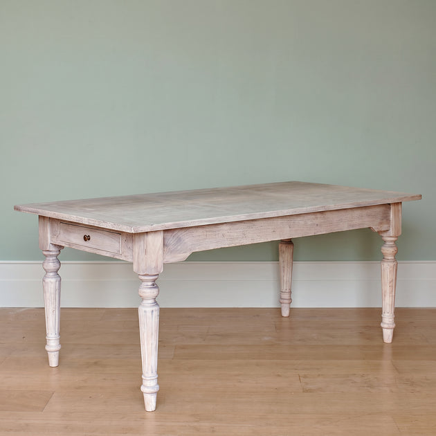 Gustavian dining table with turned legs, plain against a grey wall