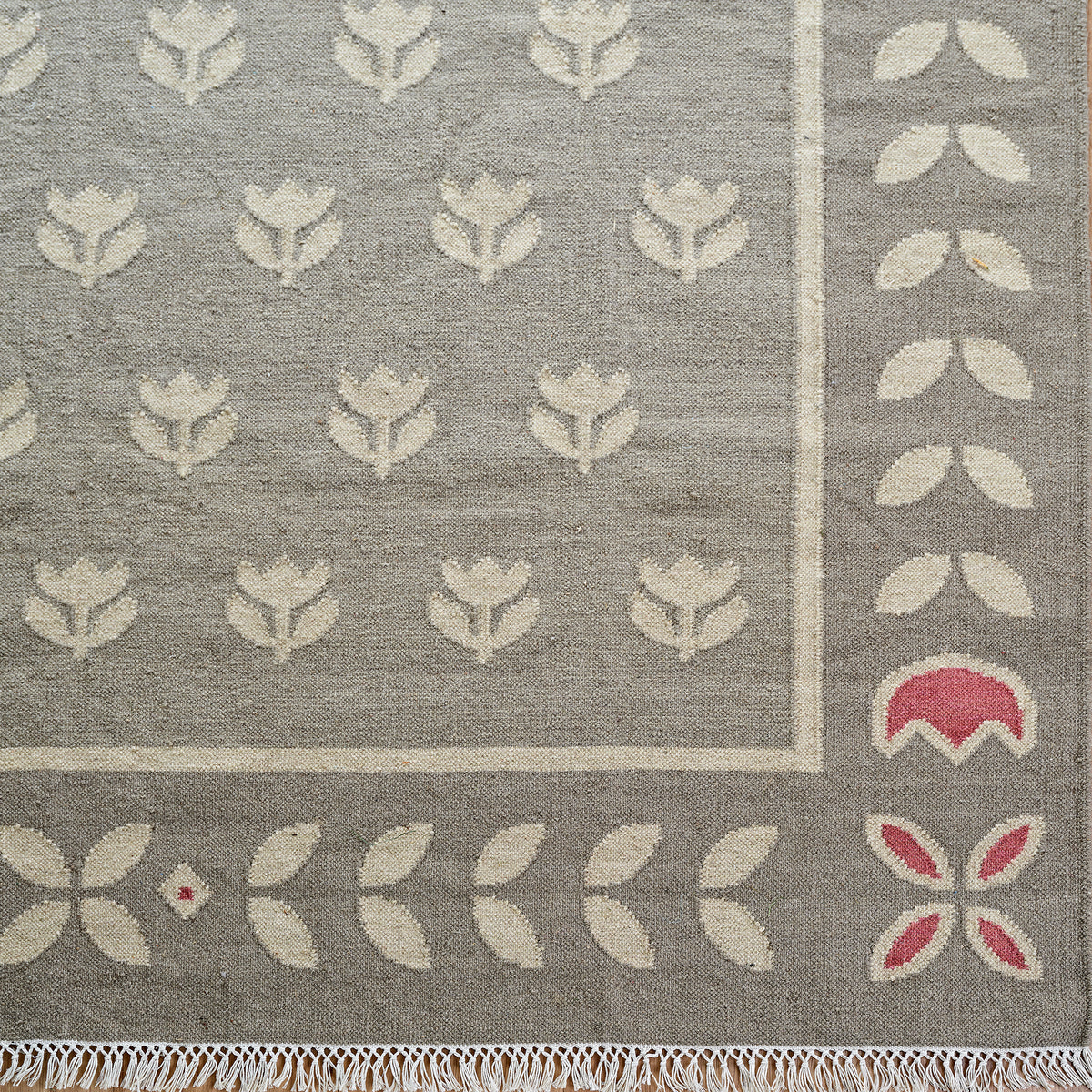 Close detail of the Smokey Blue Tulip kilim border in blue grey and cream
