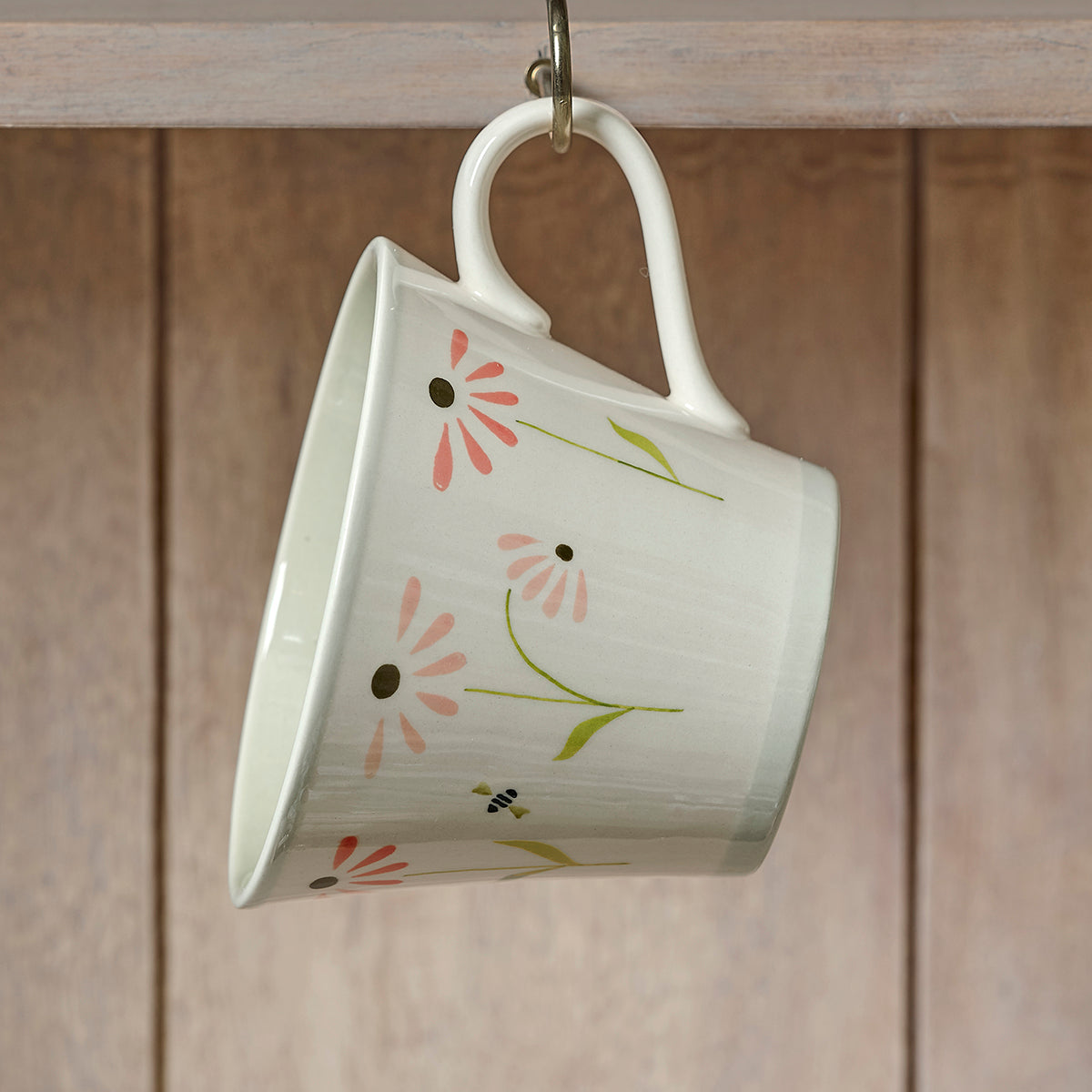 Echinacea conical mug hanging from a hook on wooden panelling