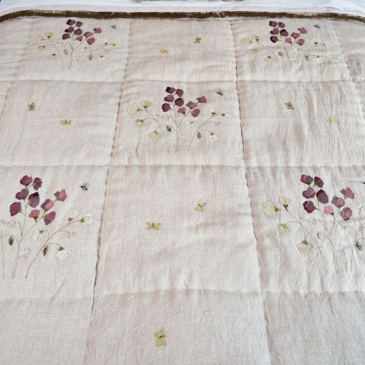 Close view of embroidered sweet peas in damson and cream