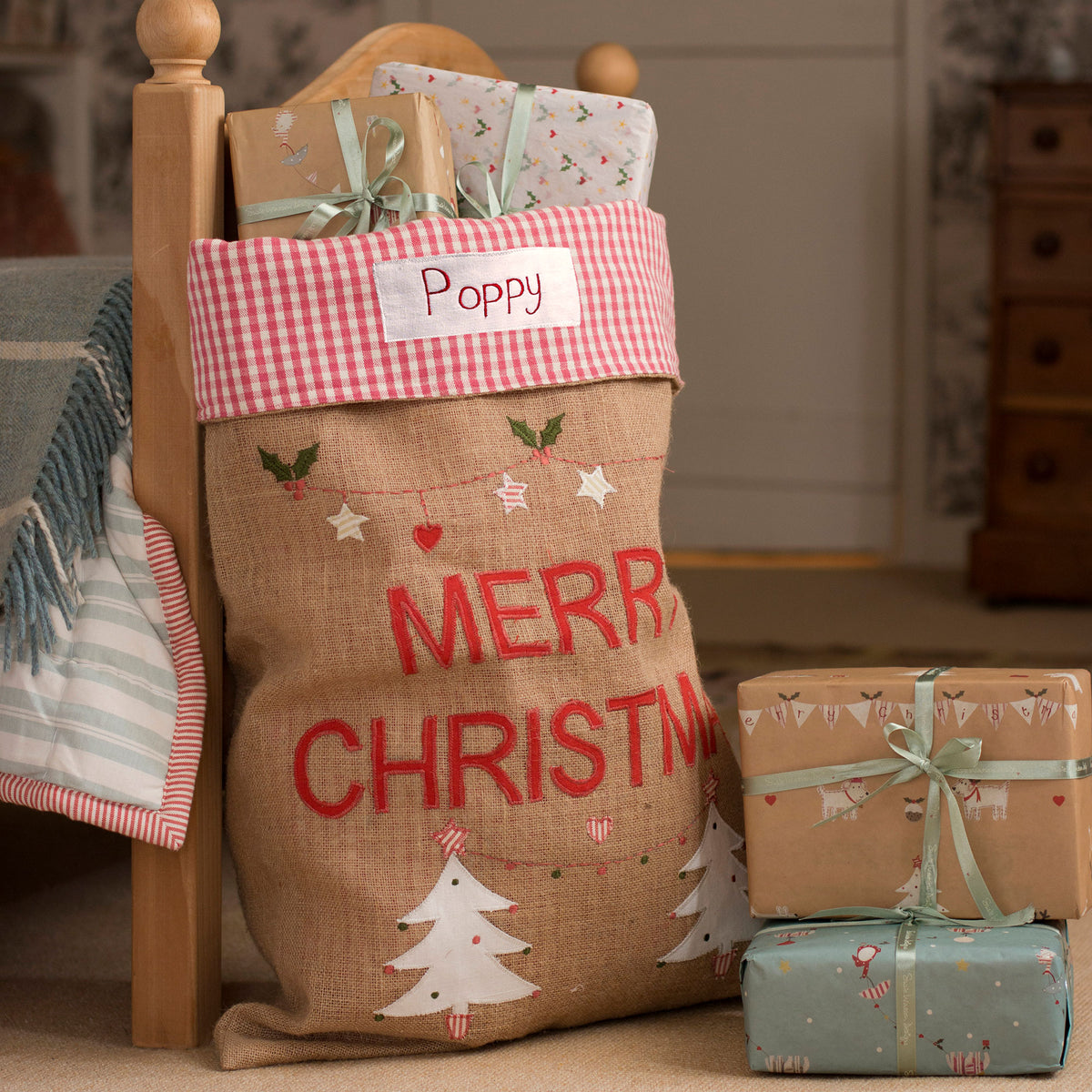 Personalised Christmas sack with a name label on a wooden bed