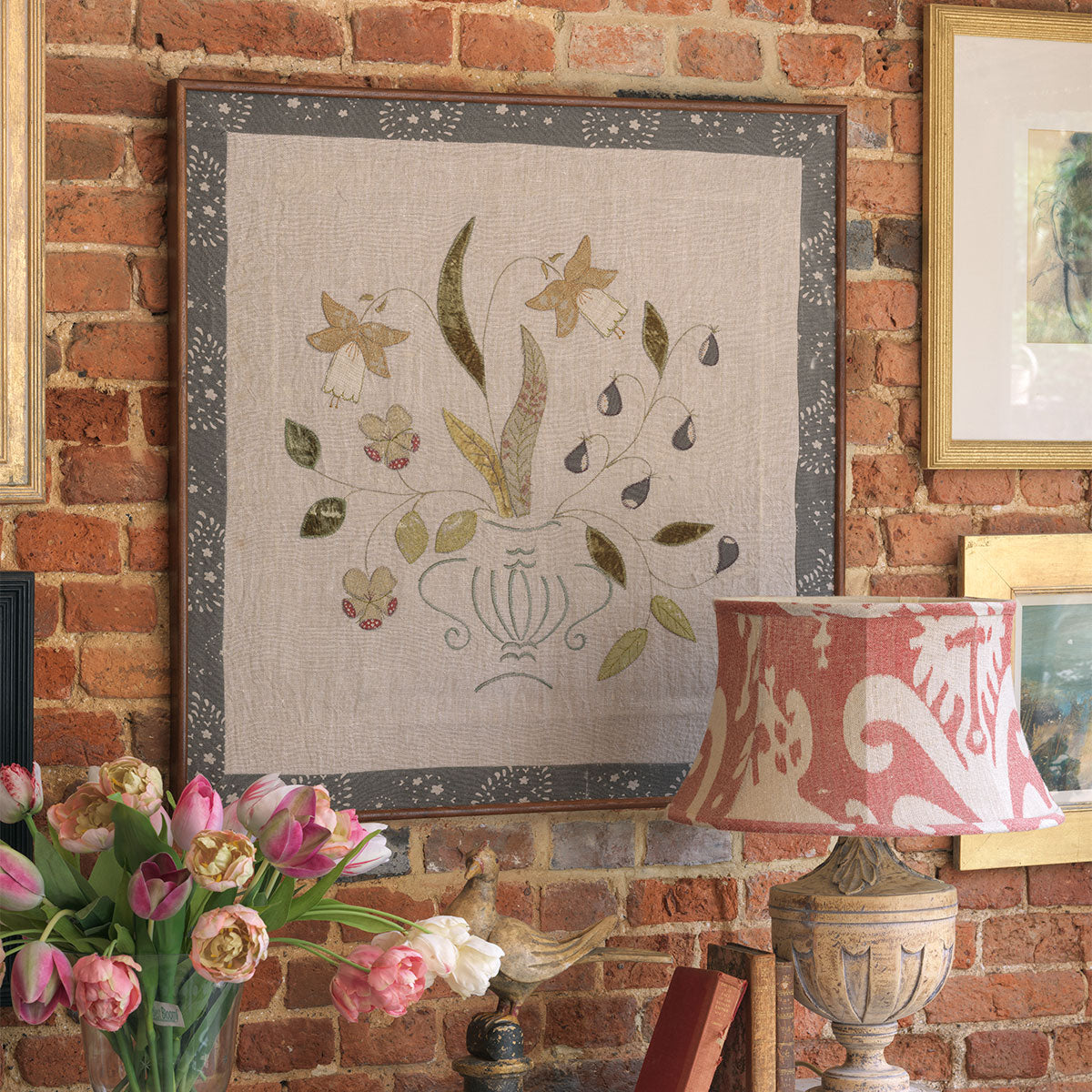 The framed figs hanging displayed on an exposed brick wall