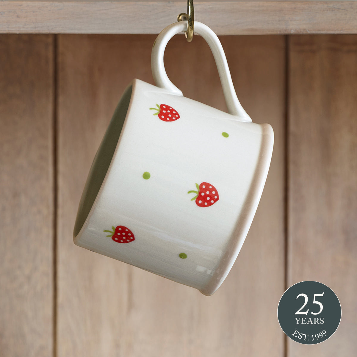 Strawberry straight mug hanging from a hook against weathered wood