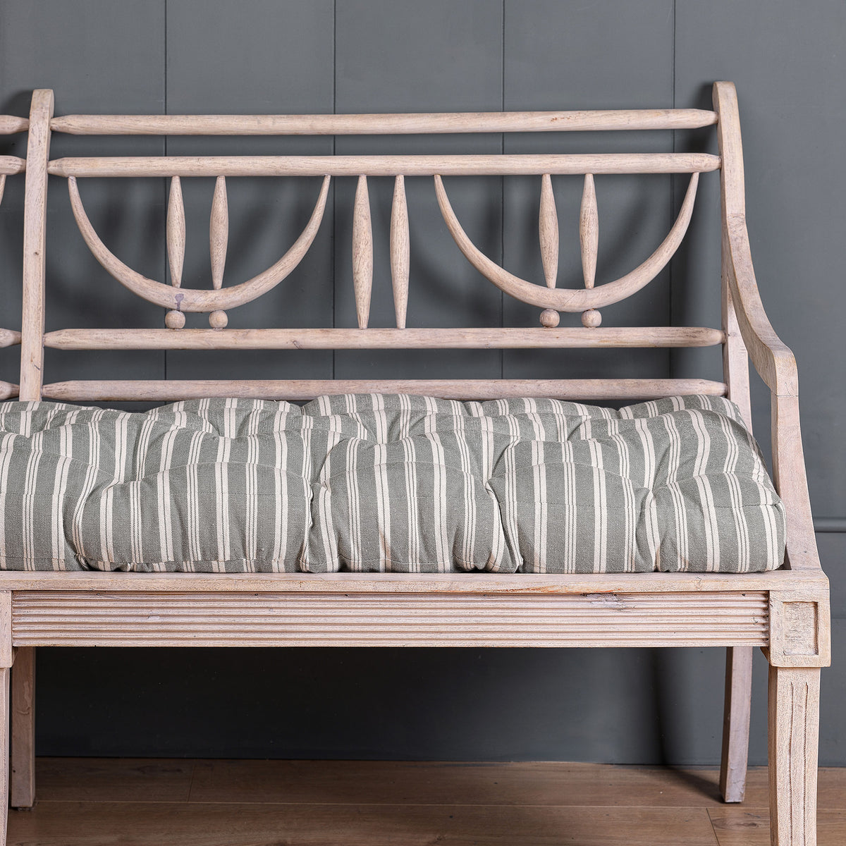 Cambridge stripe bench cushion along a painted wooden garden bench