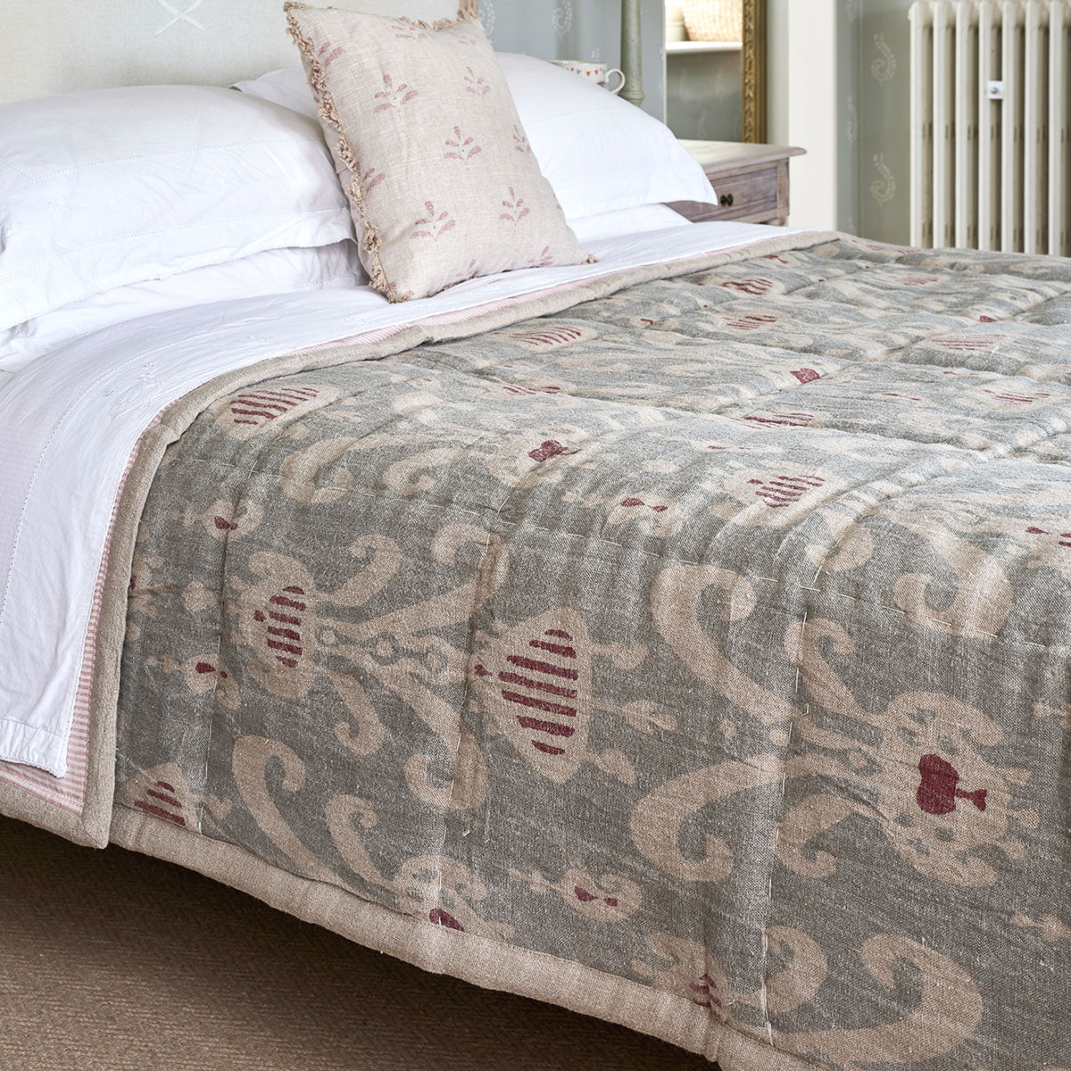 Smokey blue Natasha quilt spread over a bed with white pillows