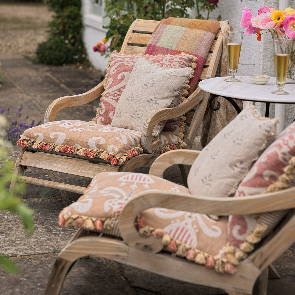 Charcoal Leaf cushions on cane garden chairs beside a small table