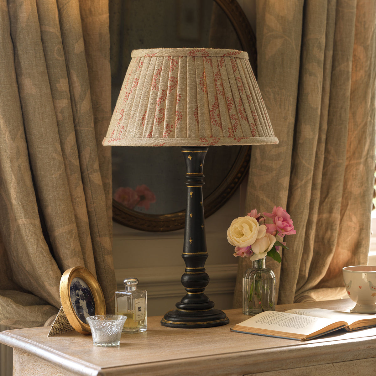 Charcoal painted Luna lamp base with pleated shade against soft linen curtains