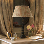 Charcoal painted Luna lamp base with pleated shade against soft linen curtains