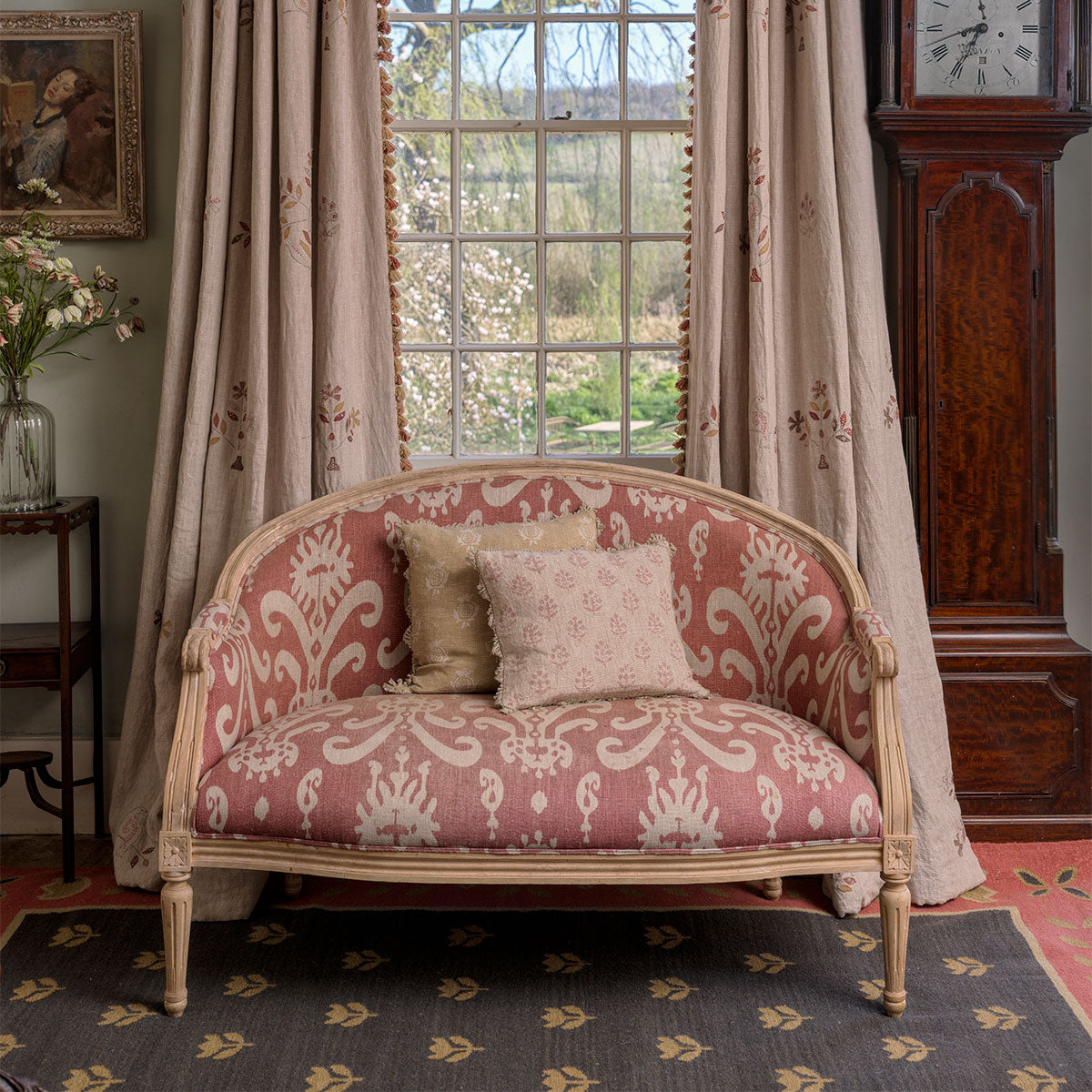 Painted settee standing on a deep blue and gold tulip kilim