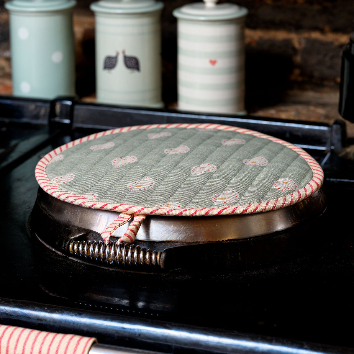 Duck egg spotted quilted Aga lid cover with pink piping on the hotplate