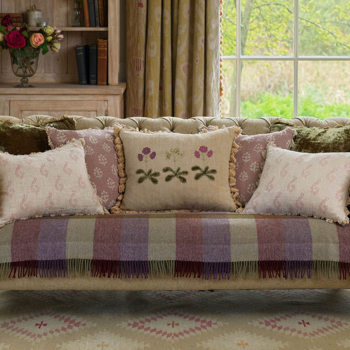 Window seat with auricula cushions and a checked wool throw
