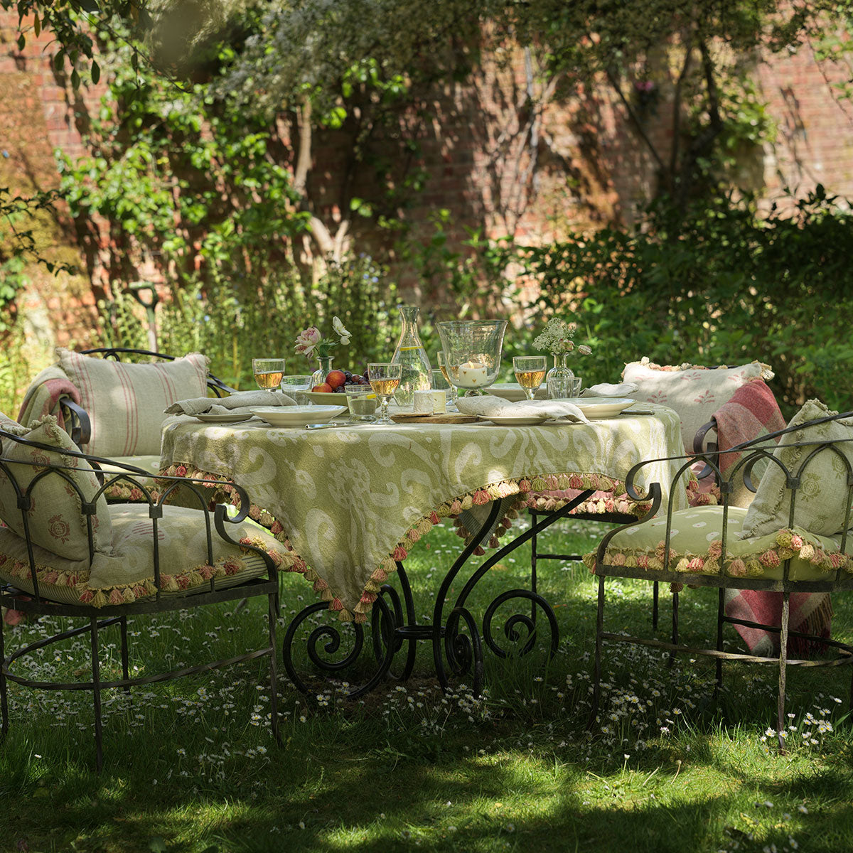 Sacha tablecloth on a garden table beneath trees, laid for lunch