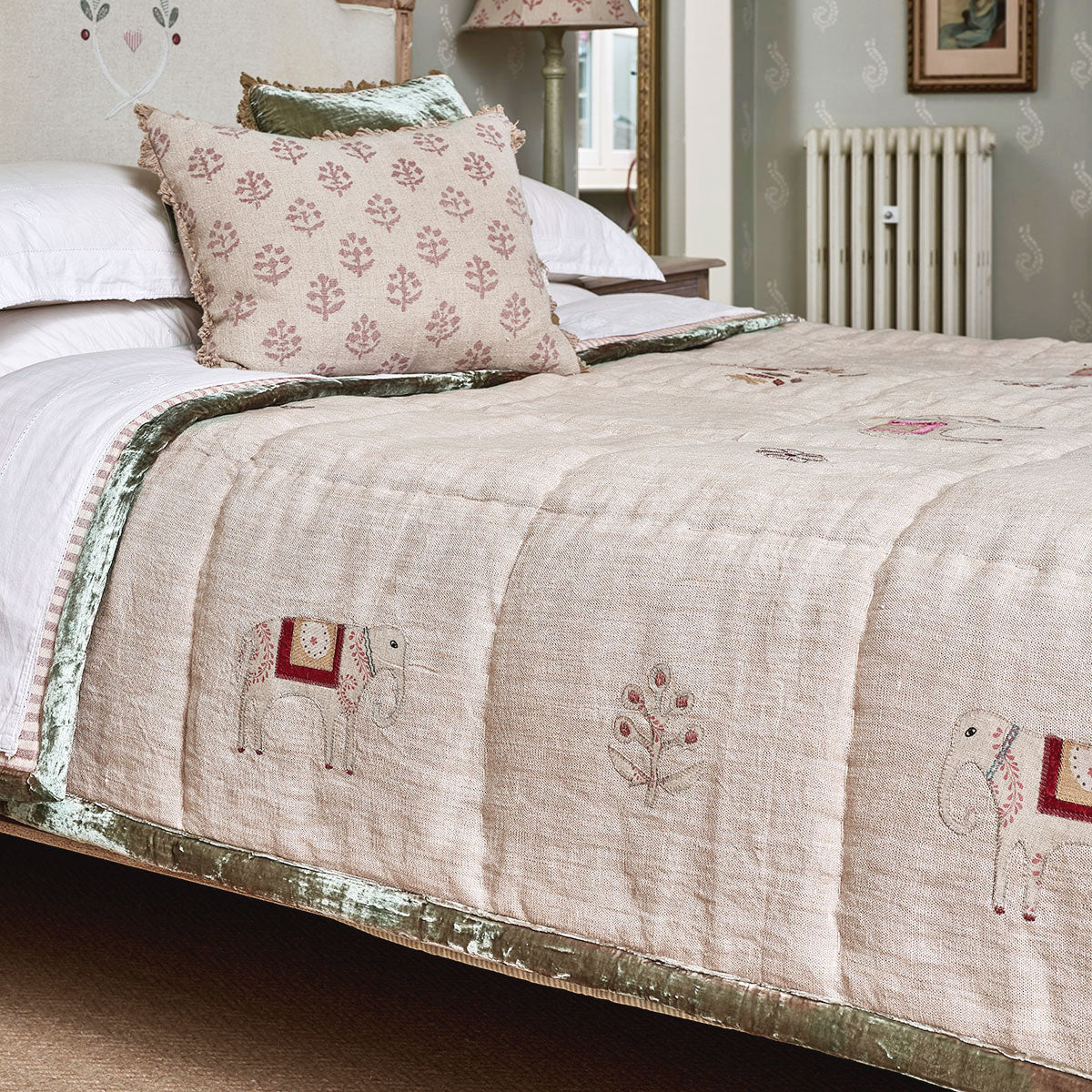 Indian Wedding quilt on a bed with green trim and elephant motifs