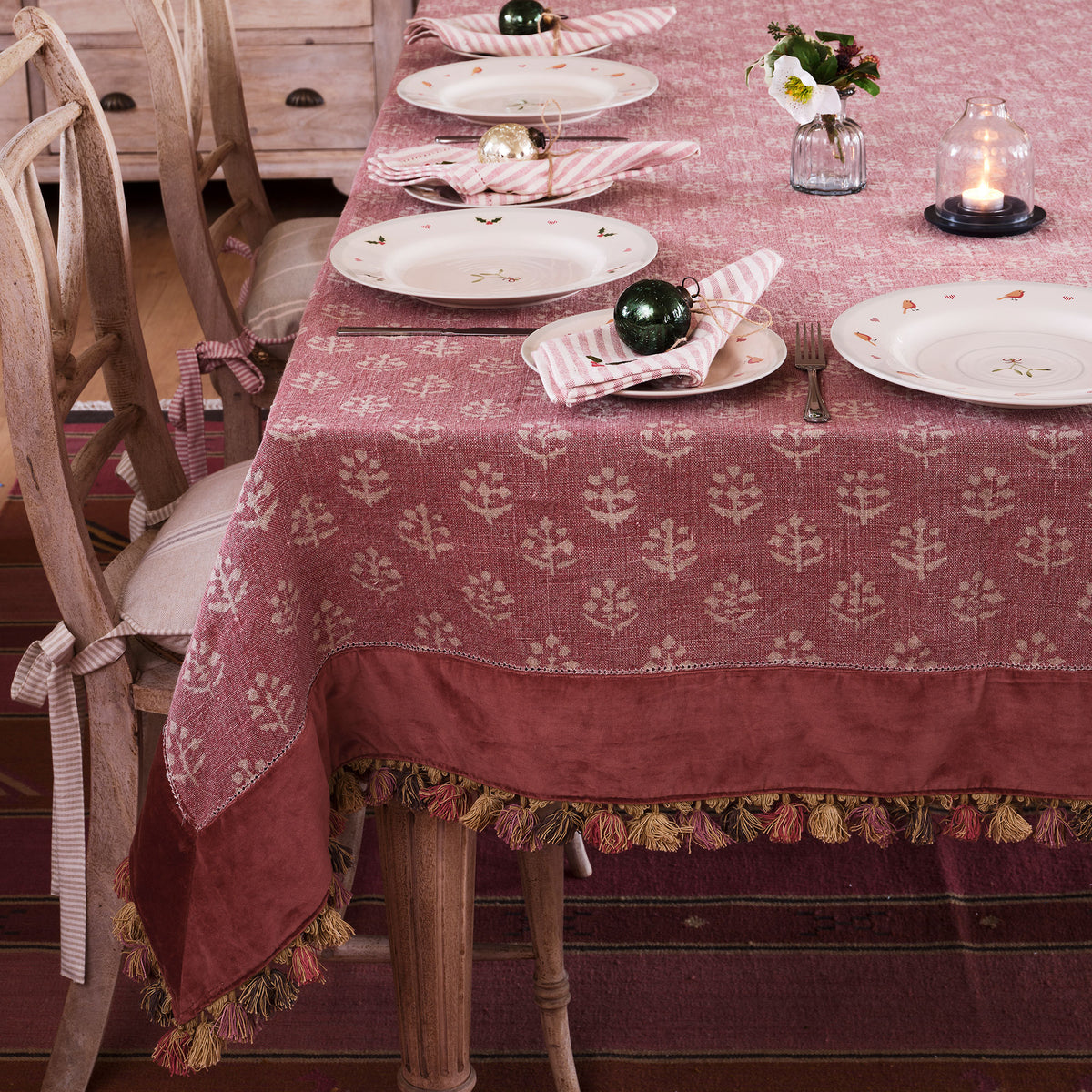 Red Earth Megha tablecloth with velvet border and tassels on a laid dining table