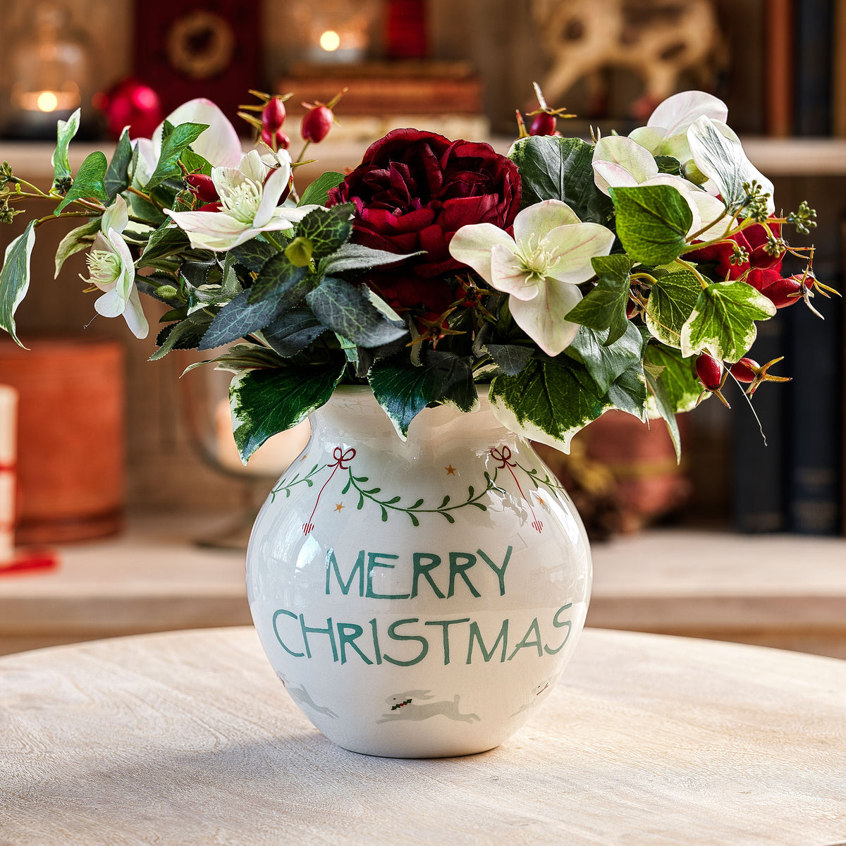 Merry Christmas round jug filled with holly and white flowers
