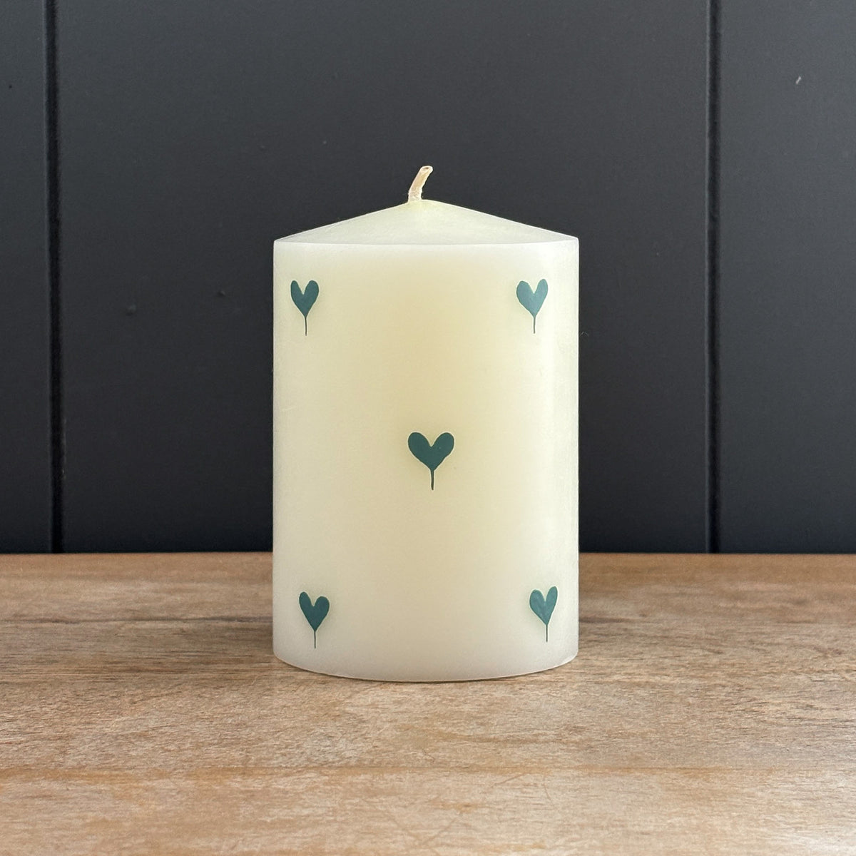 Blue Heart hand-painted pillar candle on a weathered wooden surface