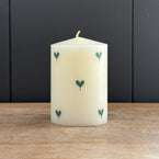 Blue Heart hand-painted pillar candle on a weathered wooden surface