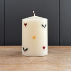 Pillar candle hand-painted with hearts and stars and holly