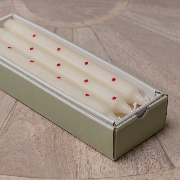 Red spot hand-painted candles laid inside their green gift box