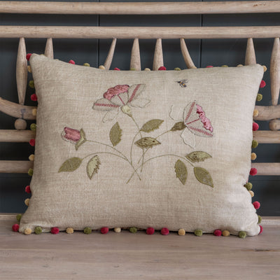 Embroidered Rosa Mundi linen cushion with rose appliqué and pom pom trim