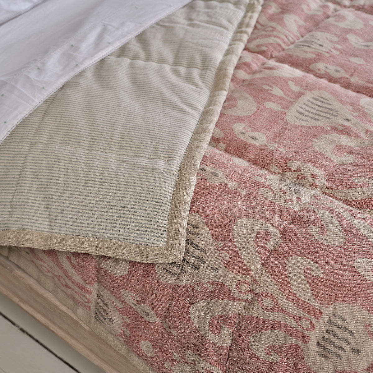 Natasha quilt turned back to show its plain quilted reverse