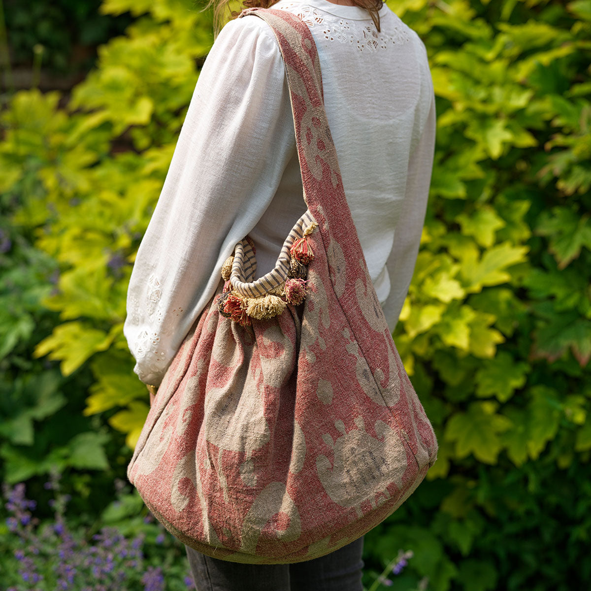 Rose Natasha slouch bag with tassels carried over the shoulder outdoors