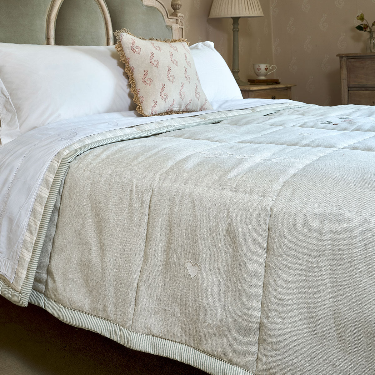 Sea Blue Gustavian quilt folded across a bed with linen cushions