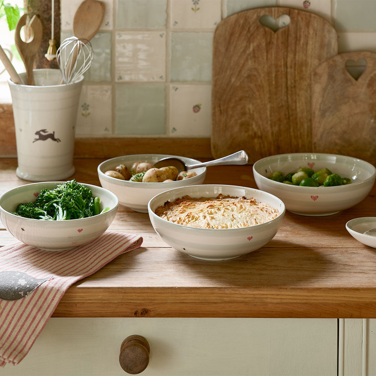 Honey Bees bowls filled with vegetables and crumble on a wooden worktop