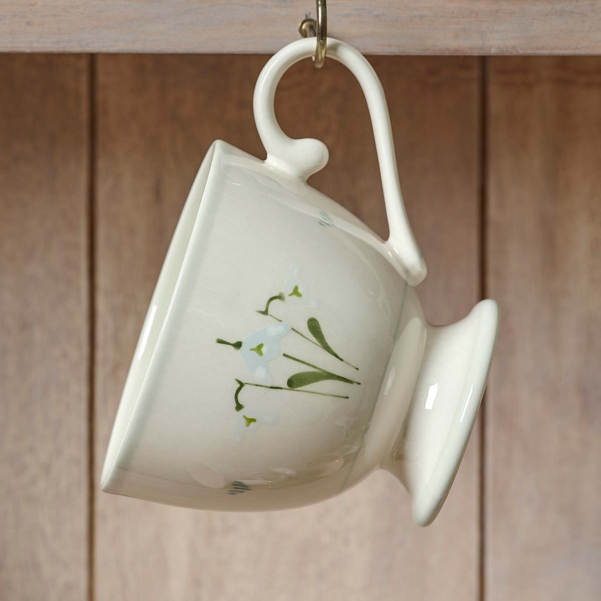 Snowdrop large mug hanging from a hook on wooden panelling