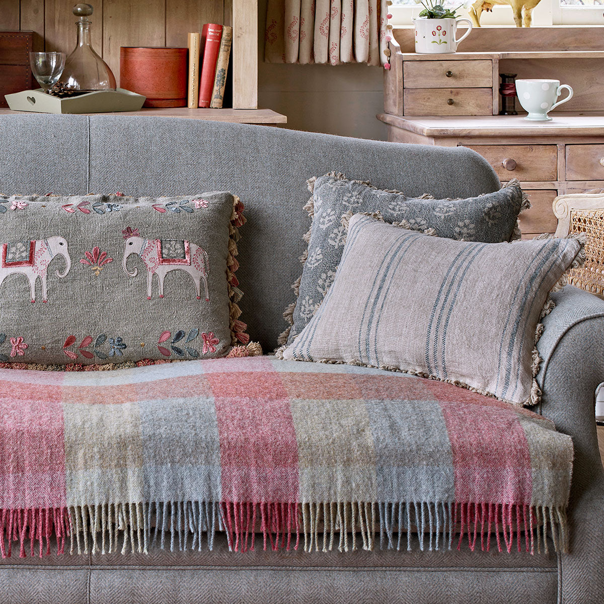 Hartford Stripe cushions on a grey sofa with check wool throw