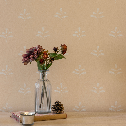 Leaf wallpaper behind a jug of autumn flowers and pine cones