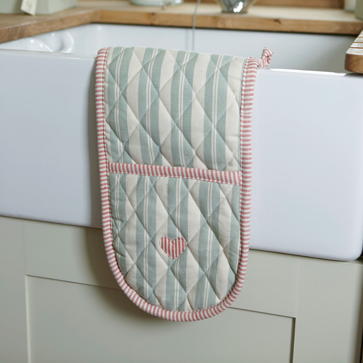 Quilted duck egg stripe oven gloves with pink heart, hung on a range