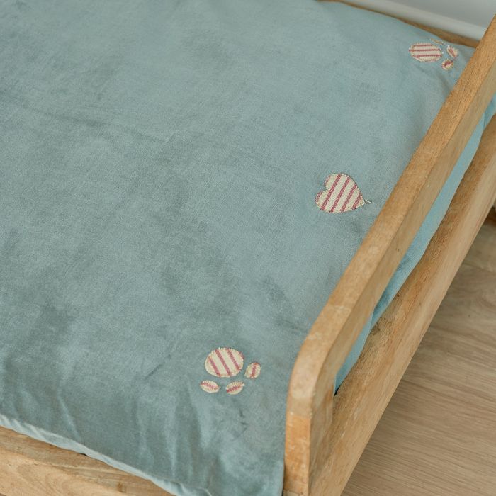 Close view of a green velvet dog mattress with embroidered paw print
