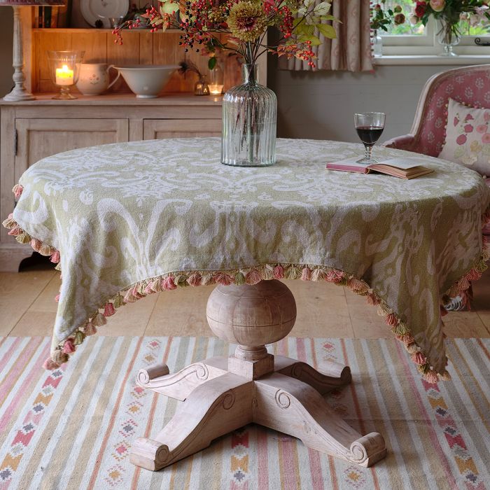 Green Sacha rustic linen cloth with tassel trim on a round table