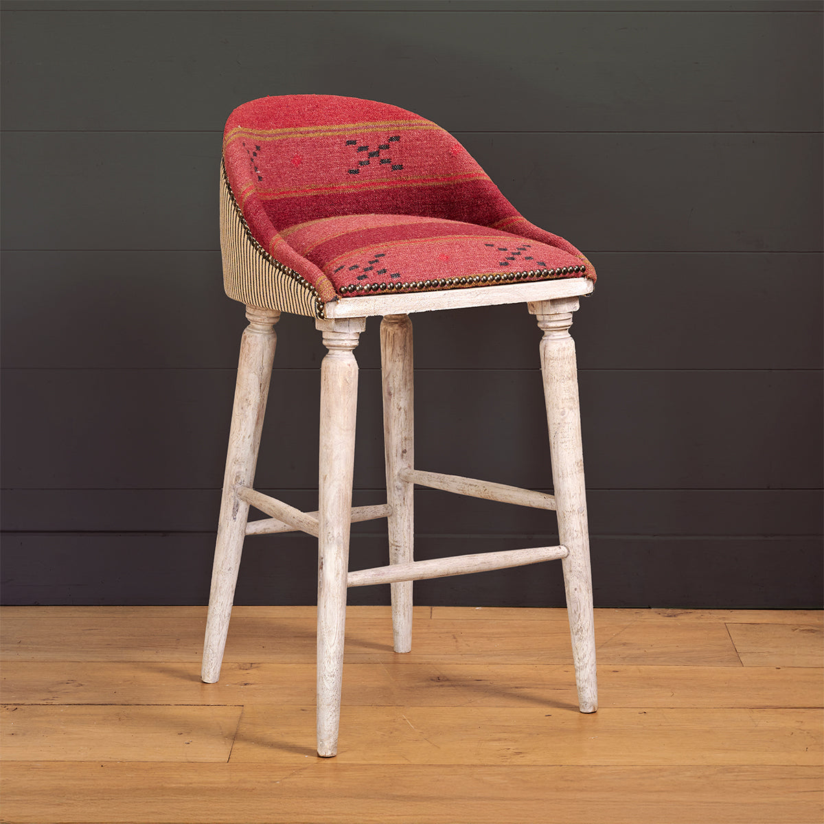 Upholstered bar stool with red kilim seat and linen back on turned pale wood legs