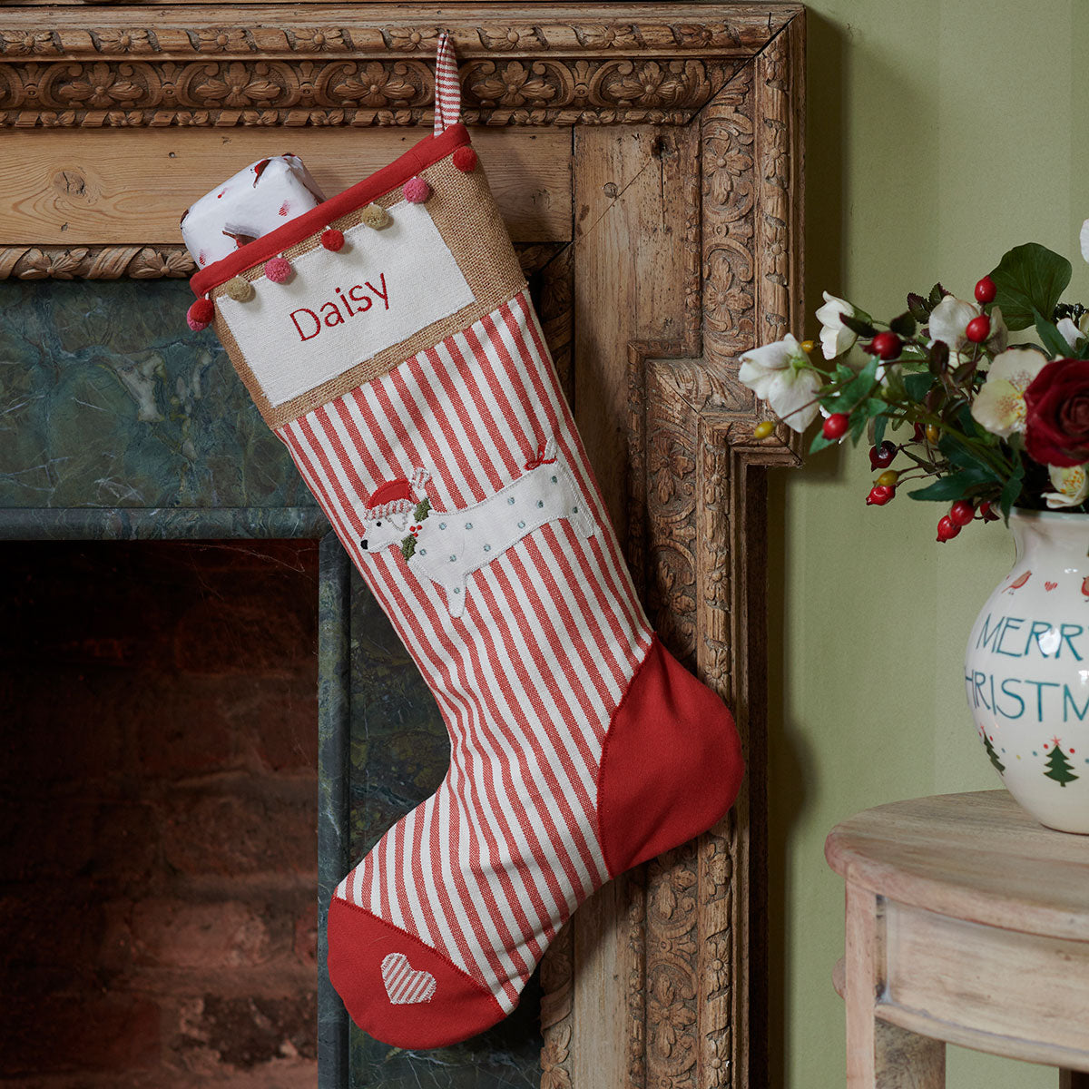 Personalised dog stocking hanging at a carved fireplace