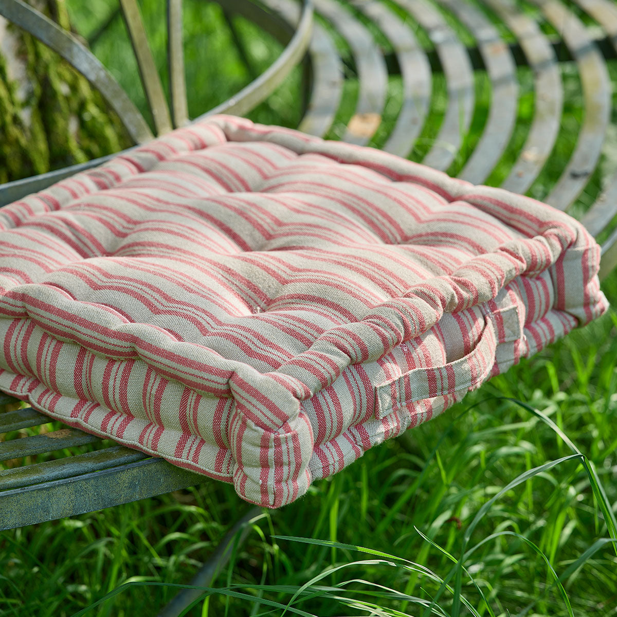 Beech sail red ticking stripe box cushion on a curved metal garden seat