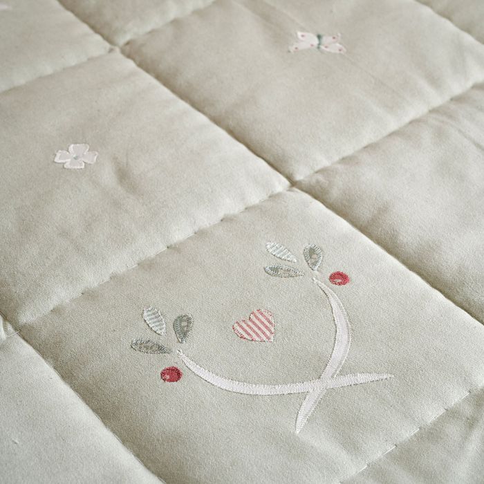 Close detail of the Gustavian quilt's embroidery and diamond quilting