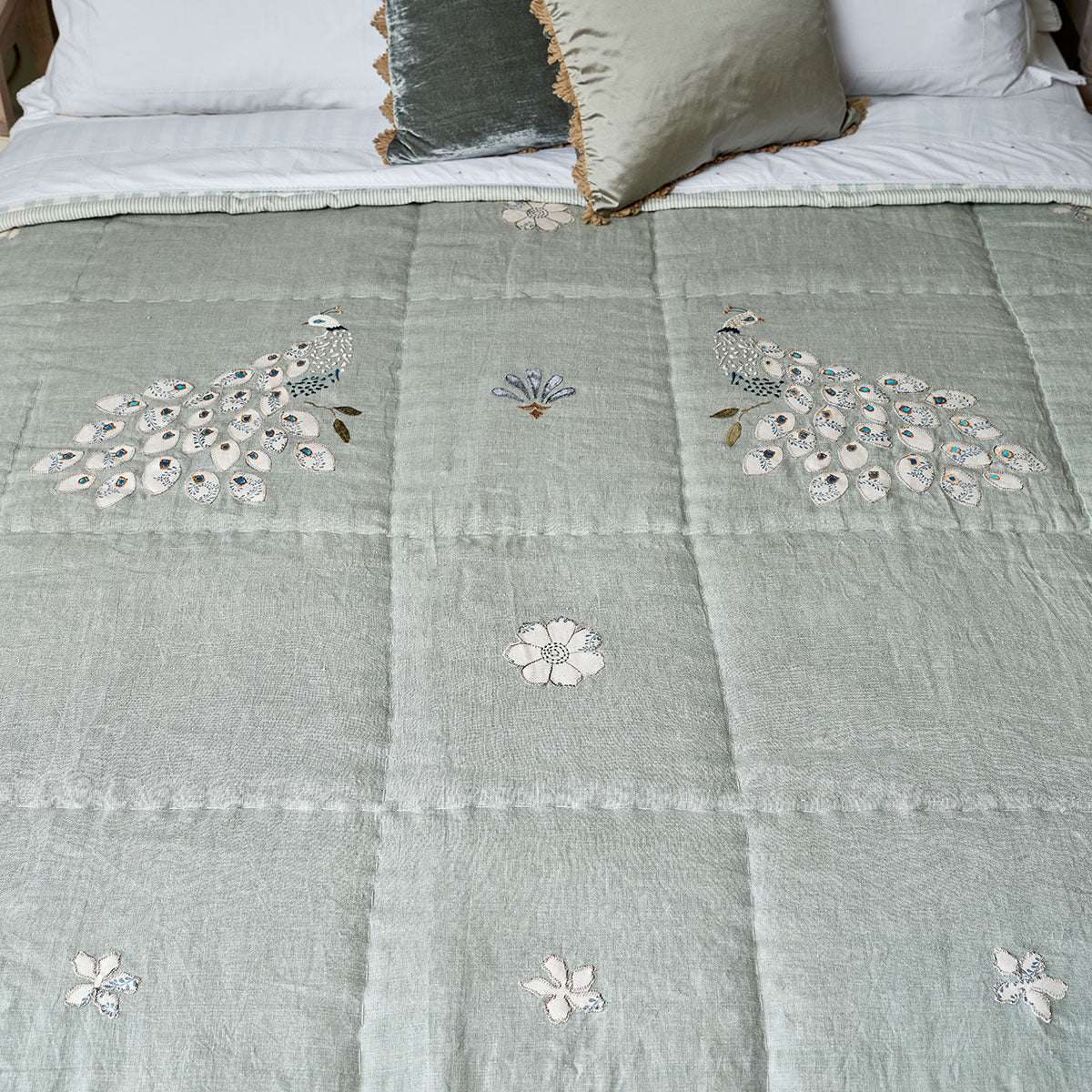 Closer view of the celadon quilt's quilted stitching and peacock embroidery