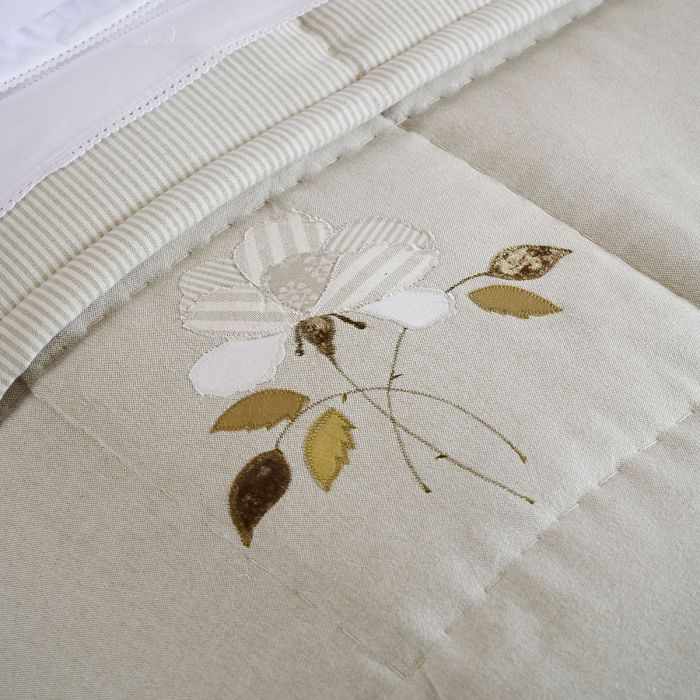 Appliqué rose and autumn leaves stitched onto the quilt, close up