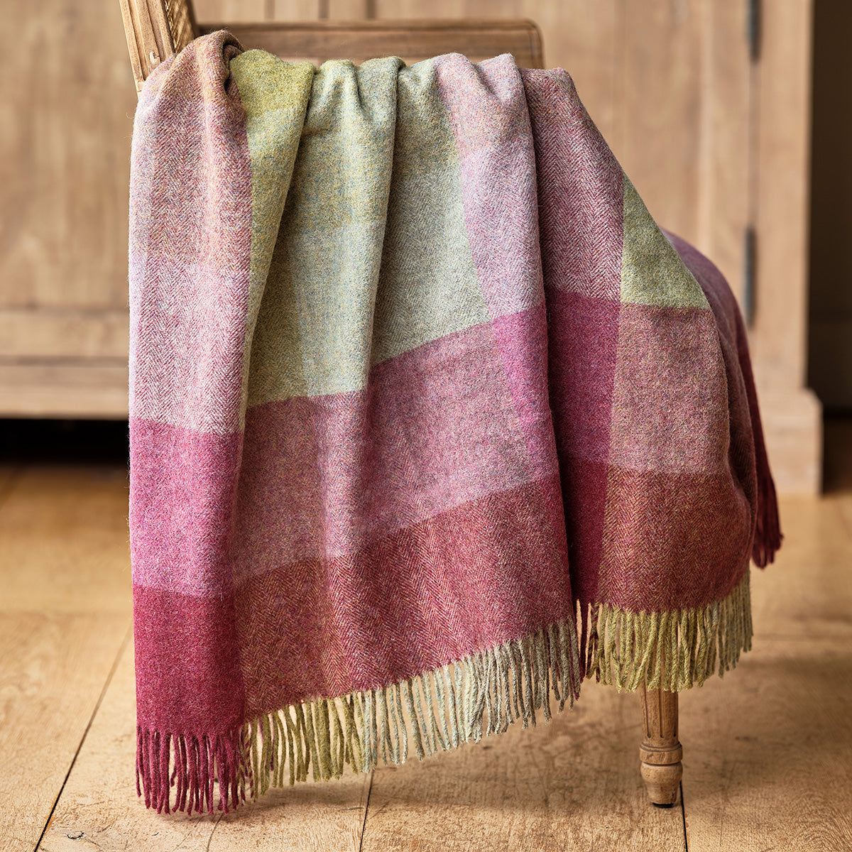 Heather mix harlequin Shetland wool throw draped over a chair, fringed