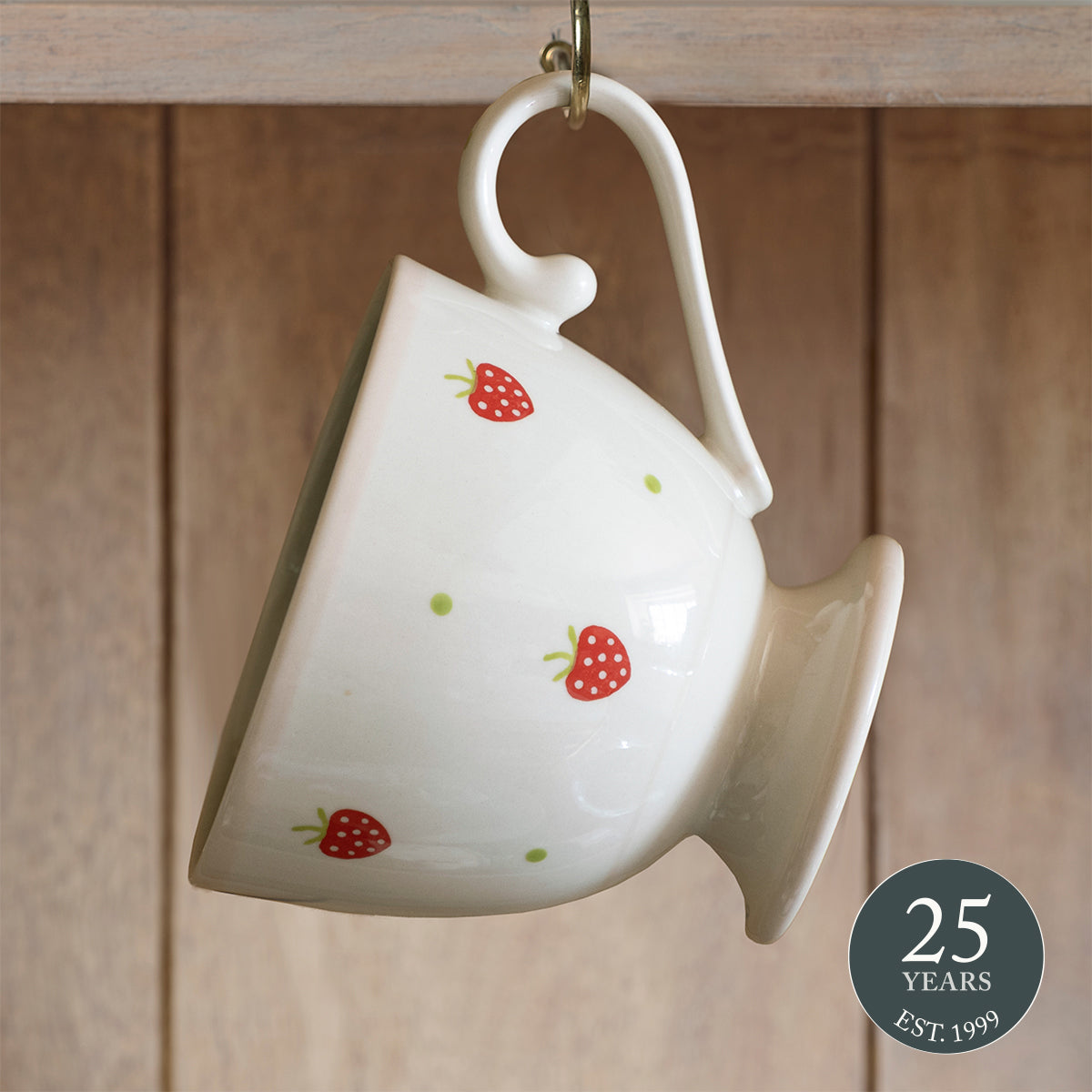 Strawberry large mug tipped on its side against wooden panelling