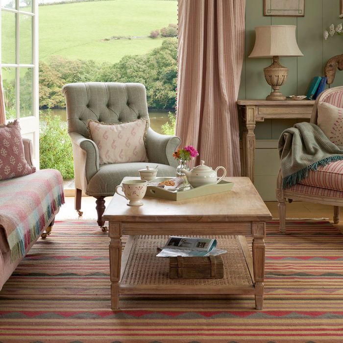 Button back armchair in a sitting room with sofa and striped rug
