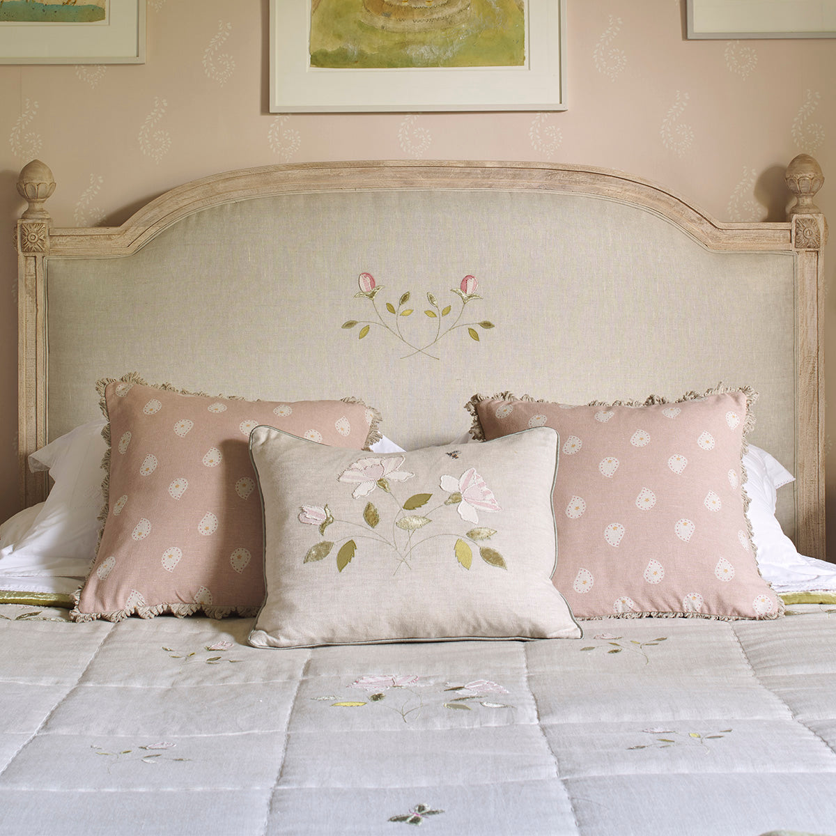 Dusky Pink Mika and spot cushions on an embroidered bedspread