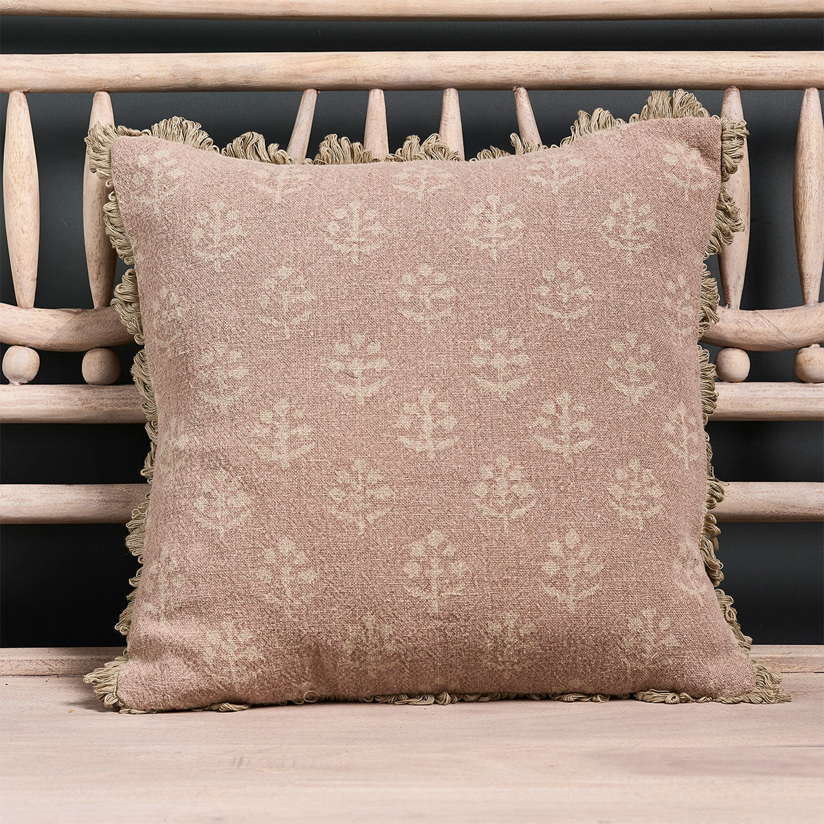 Reverse Dusky Pink Megha linen cushion with fan edge on a bench