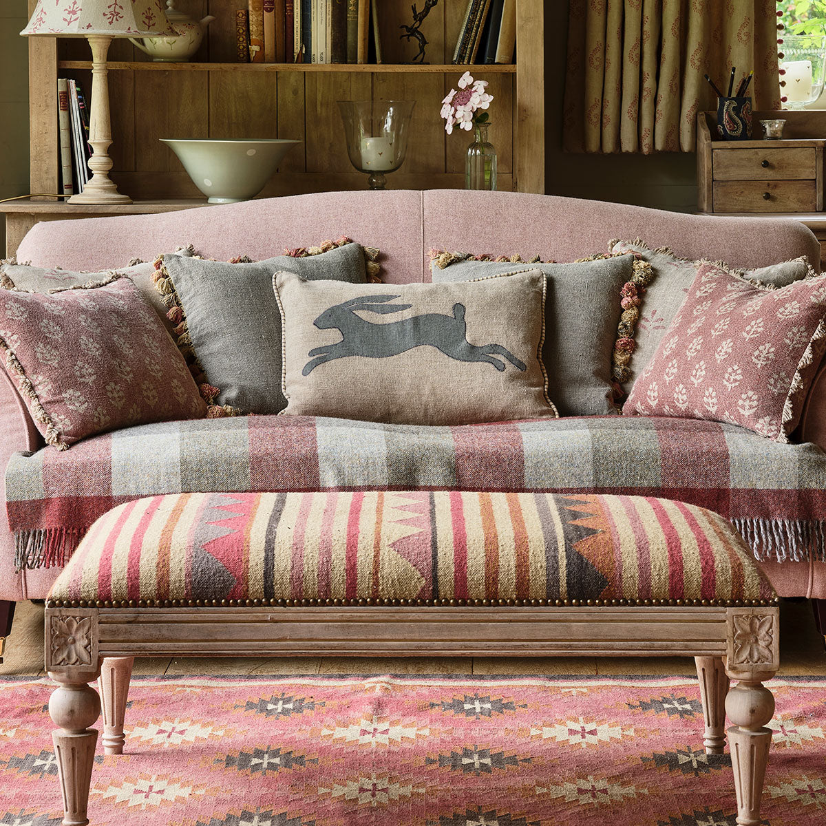 Smokey blue cushions among patterned cushions on a striped sofa
