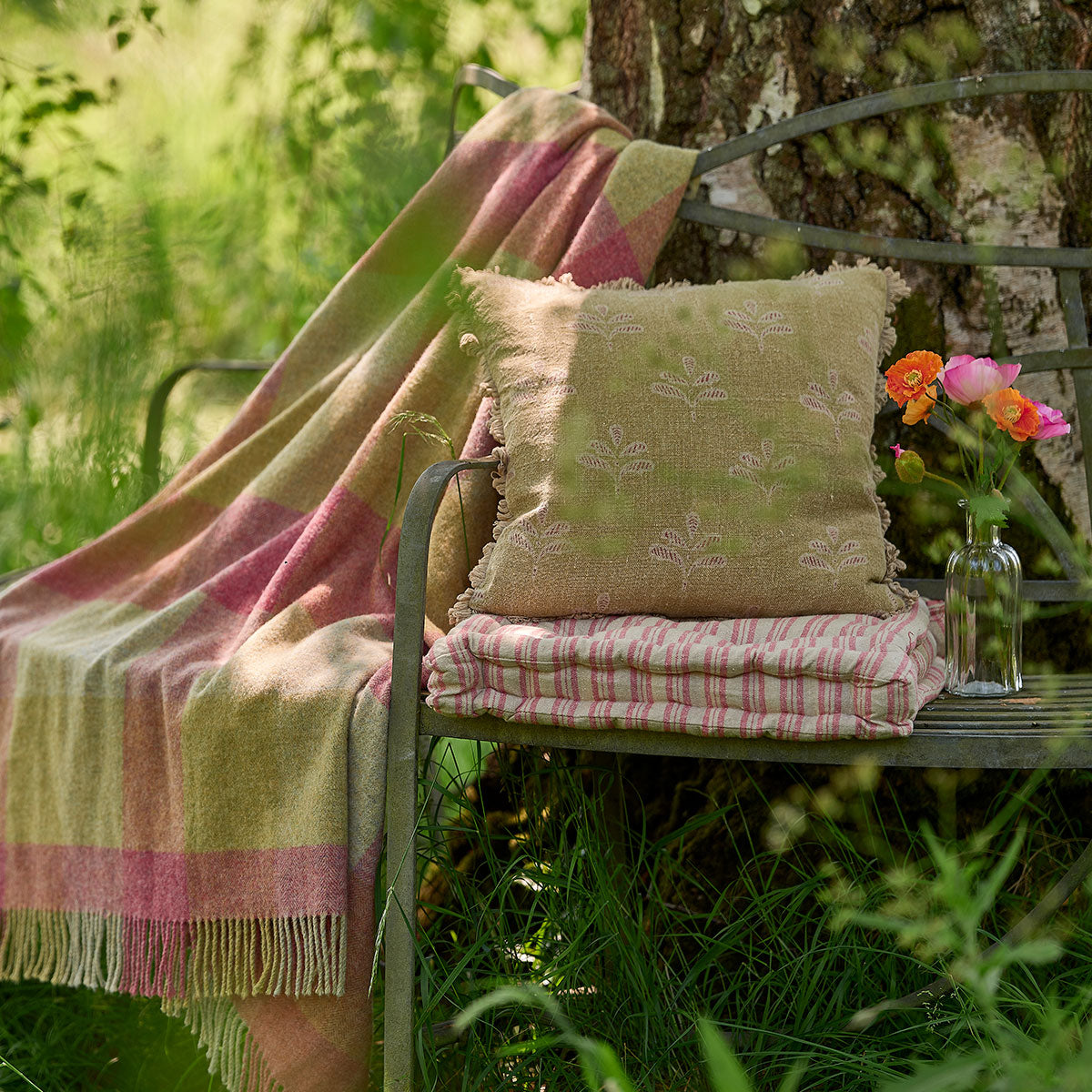 Summer Green Reverse Leaf cushion on a garden chair beneath a tree