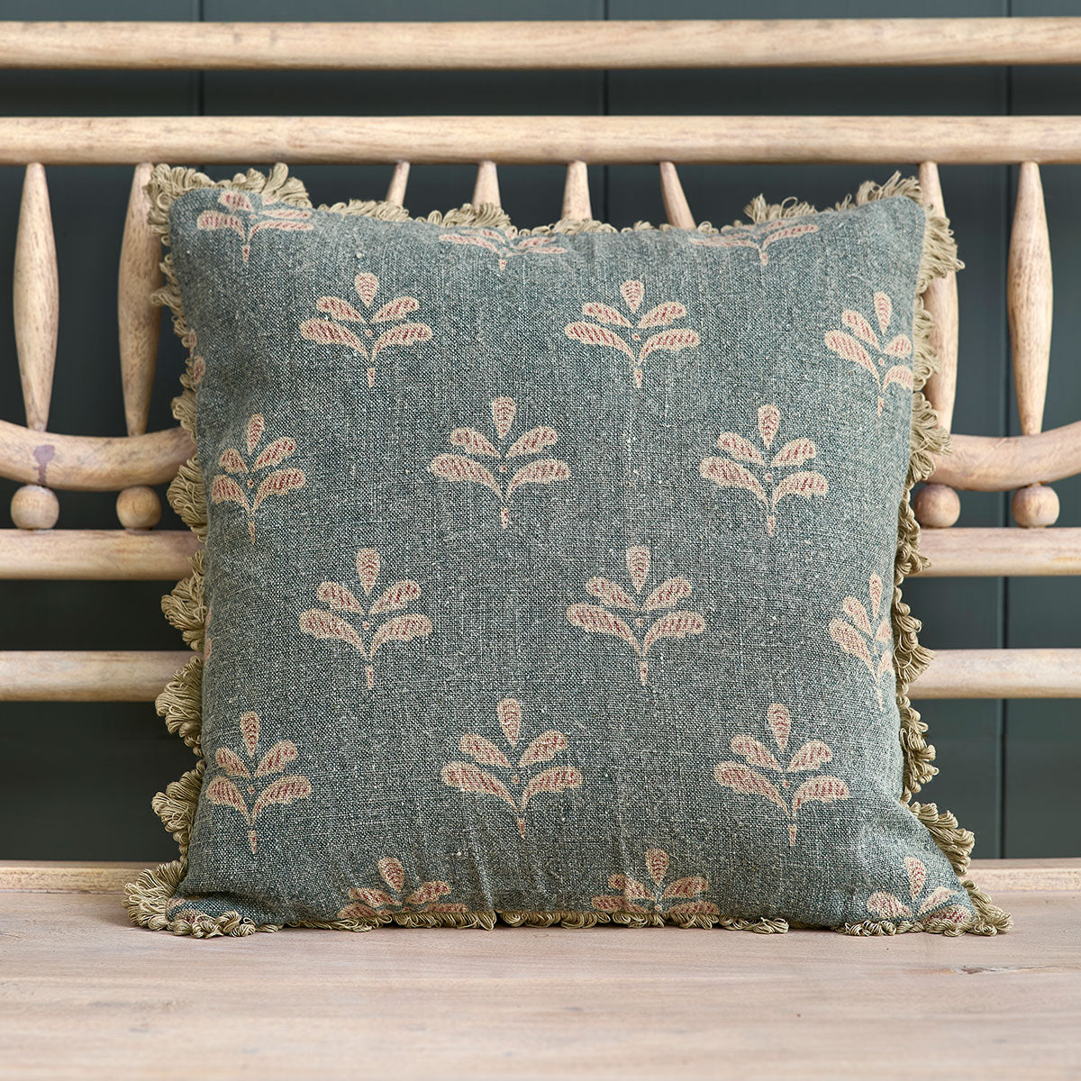 Summer Blue Reverse Leaf linen cushion with tassel trim on a bench